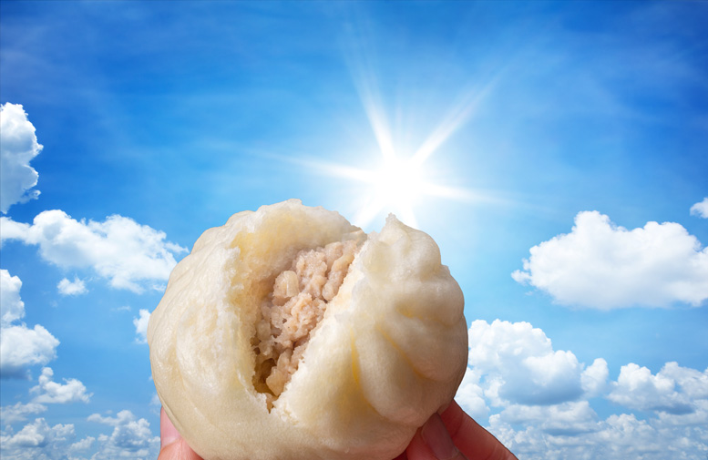 青空と太陽を背景にした中華まん