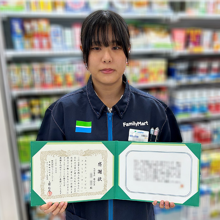 感謝状を持ったストアスタッフの写真