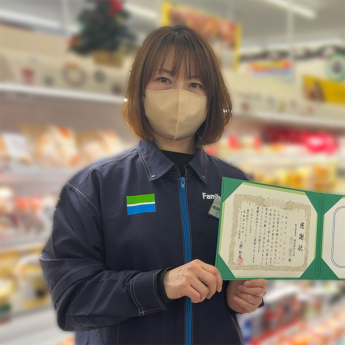 感謝状を持ったストアスタッフの写真