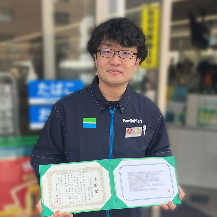 感謝状を持った店舗スタッフの写真