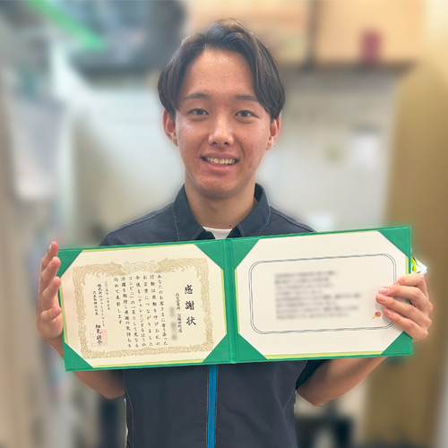 感謝状を持ったストアスタッフの写真