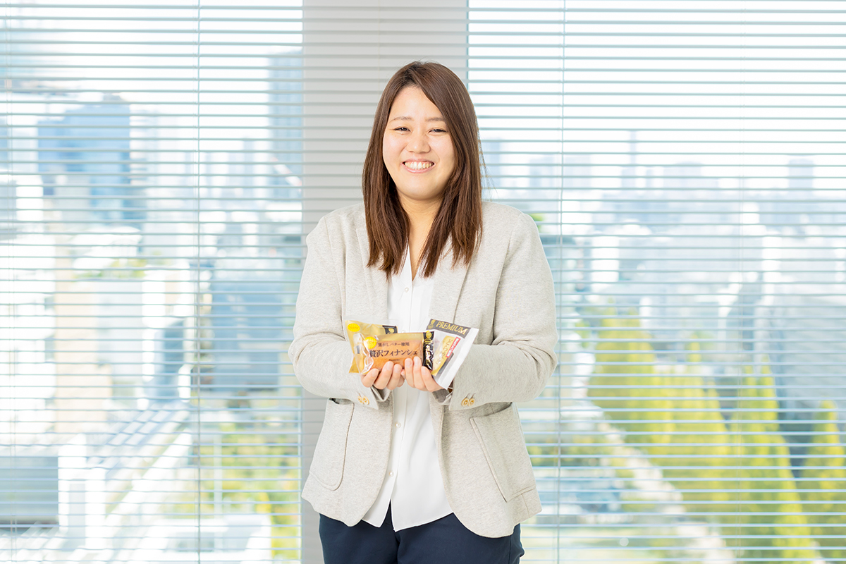 ファミマルPREMIUM 焼き菓子・和菓子を持った笑顔の松本さんの写真