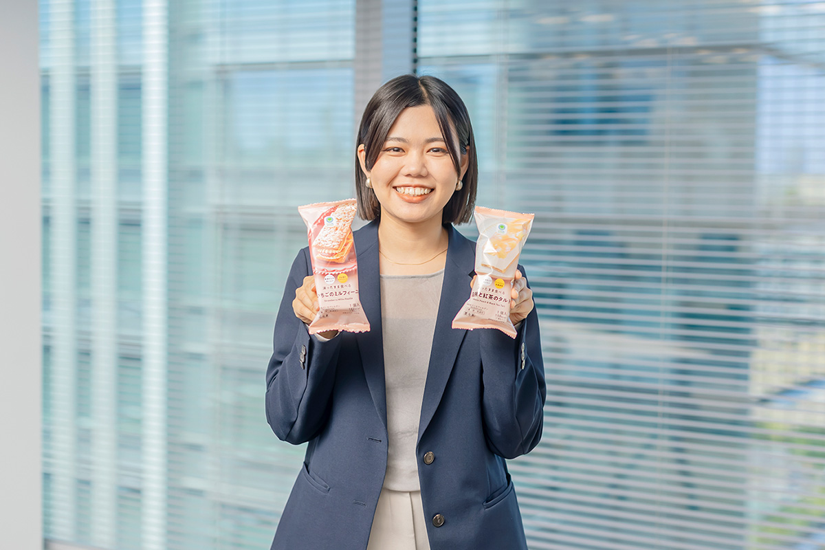 商品を持った笑顔の重田さんの写真