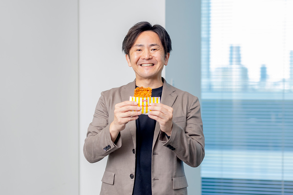 商品を持った笑顔の和田さんの写真