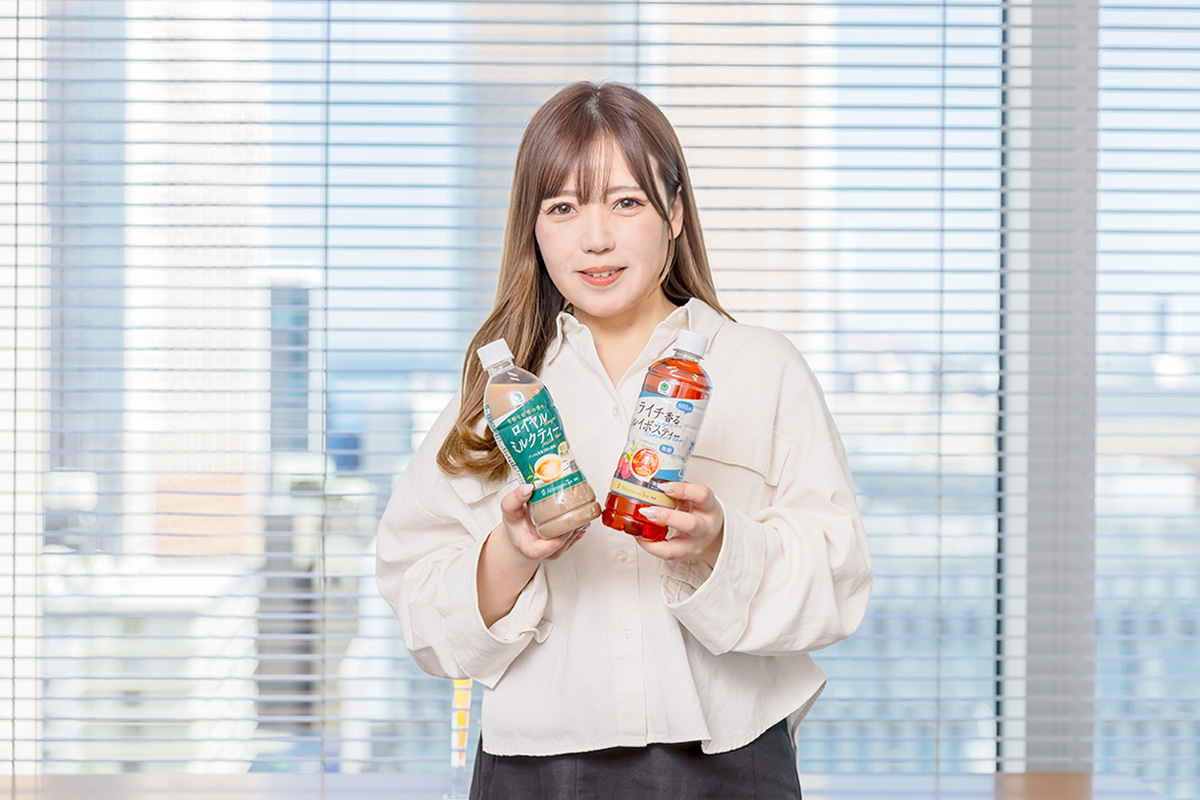 商品を持った笑顔の櫛田さんの写真