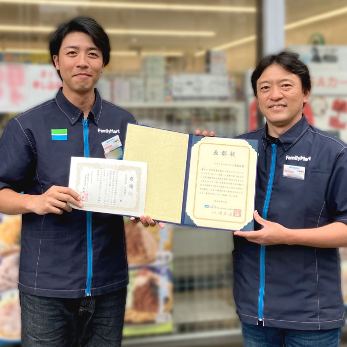 感謝状を持ったストアスタッフの写真