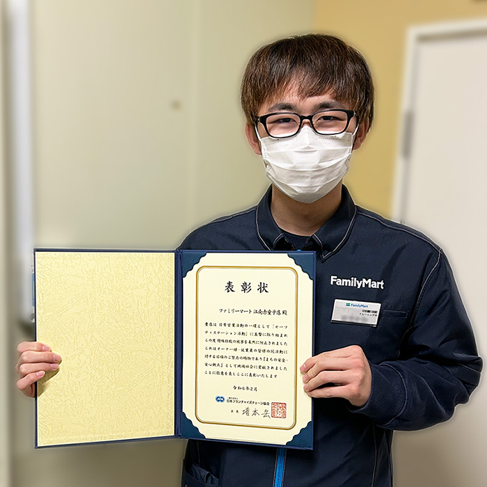 感謝状を持ったストアスタッフの写真