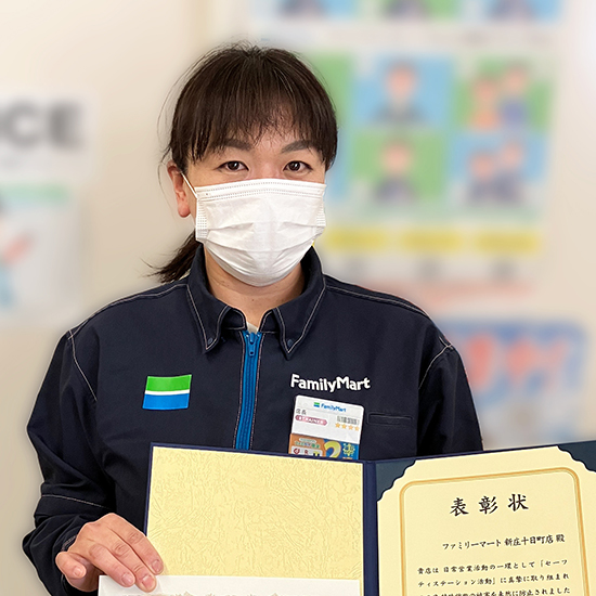 感謝状を持ったストアスタッフの写真