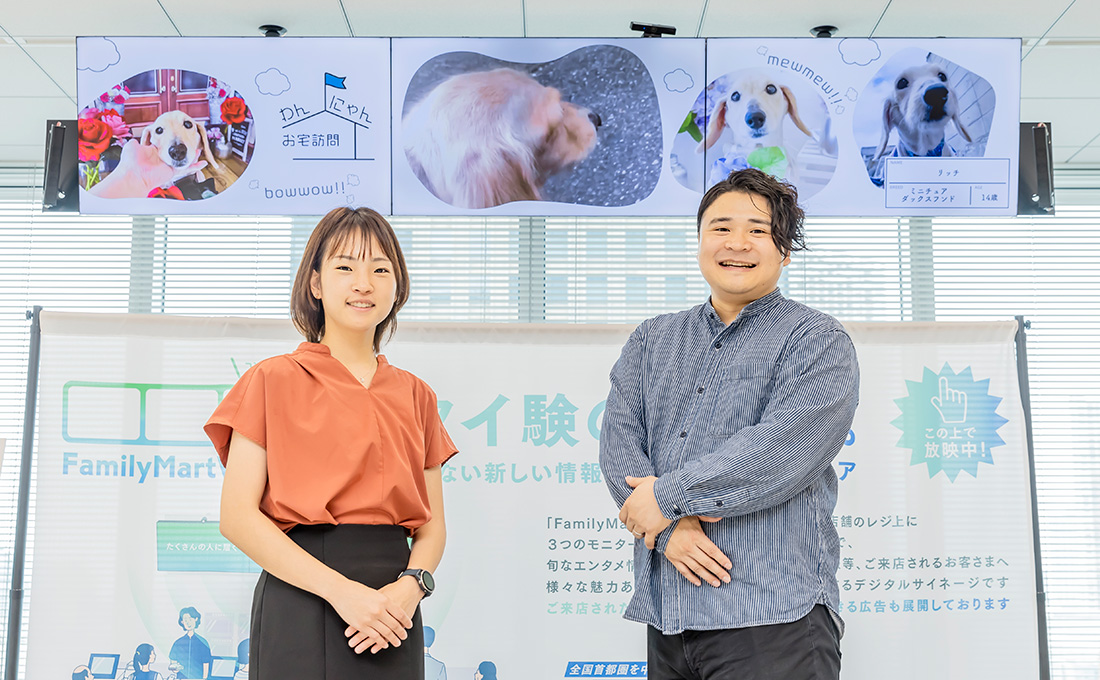 FamilyMartVisionをバックにした笑顔の田島さんと石川さんの写真