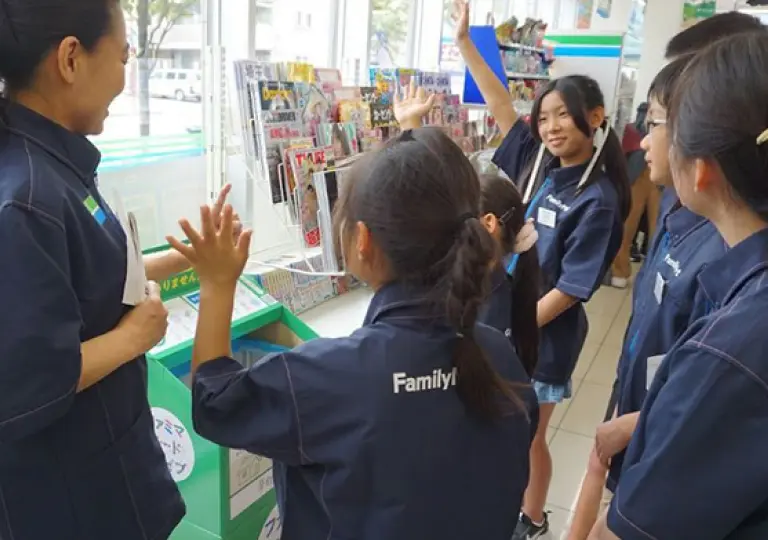 ファミマフード ドライブ の 取り組みについて 説 明を受けるこどもたち