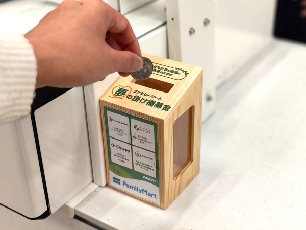 募金箱にお金を投入している様子