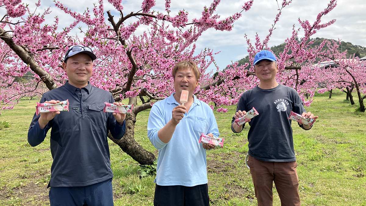 商品を手に笑顔の農家さんの写真
