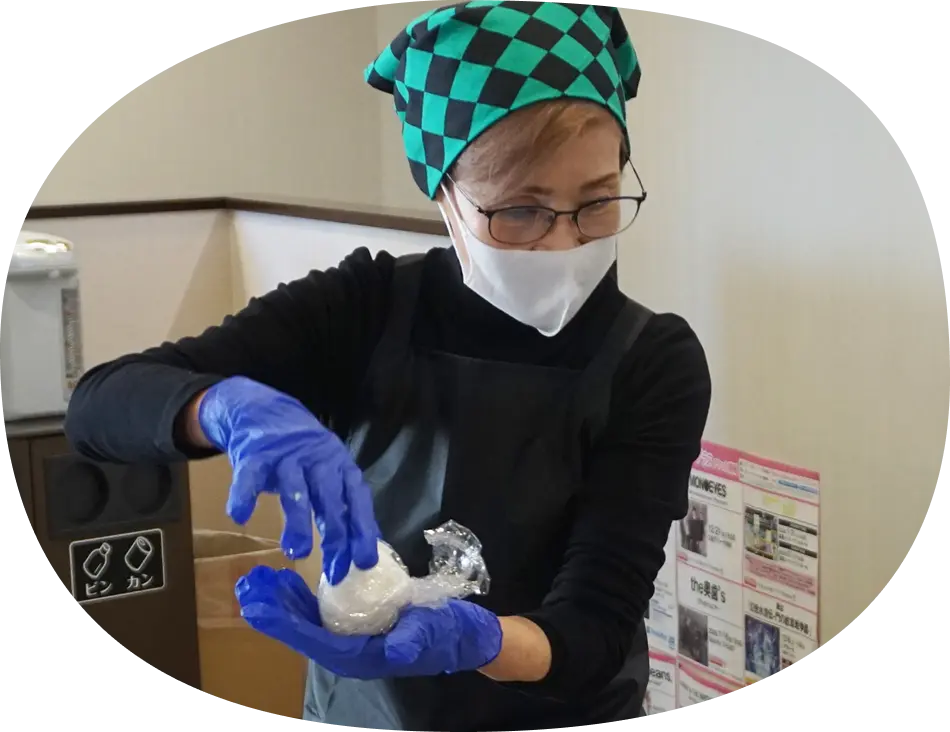 右近さんがおむすびの作り方を 教えているところ