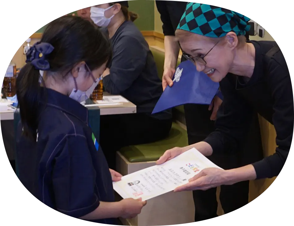 女の子に弟子認定証を 手渡す右近さん