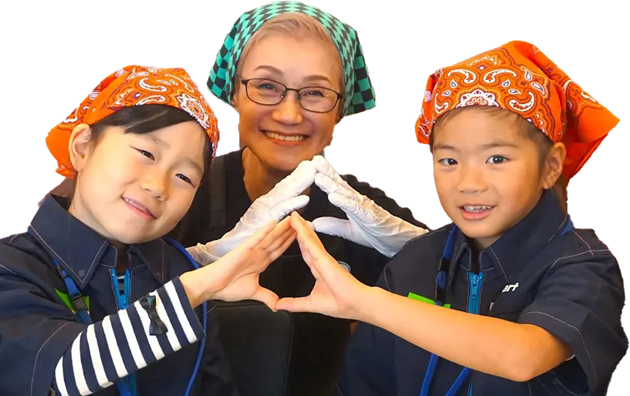 手でおむすびの形を作り、 笑顔を見せる右近さんとこどもたち